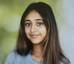 A young Indian woman with long dark hair smiles